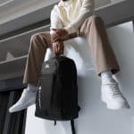 a man sitting on a ledge with a backpack