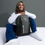 a woman sitting on a white surface with a backpack