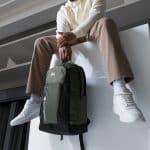 a man sitting on a ledge with a backpack