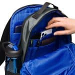 a hand putting a phone in a backpack